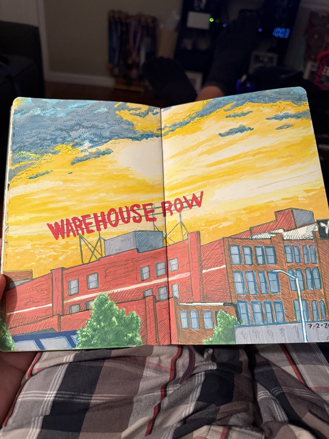 Color sketchbook drawing of Chattanooga's Warehouse Row beneath a broad yellow and blue sky.
